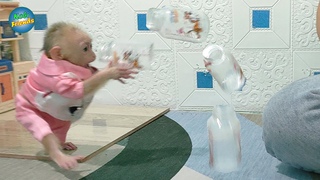 Baby monkey Kobi doing funny while taking the bottle
