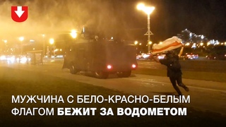 Мужчина с бело-красно-белым флагом побежал за водометом